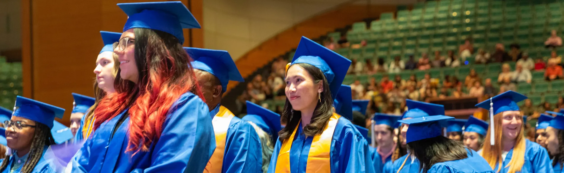 students wearing caps and gowns in the commencement hall