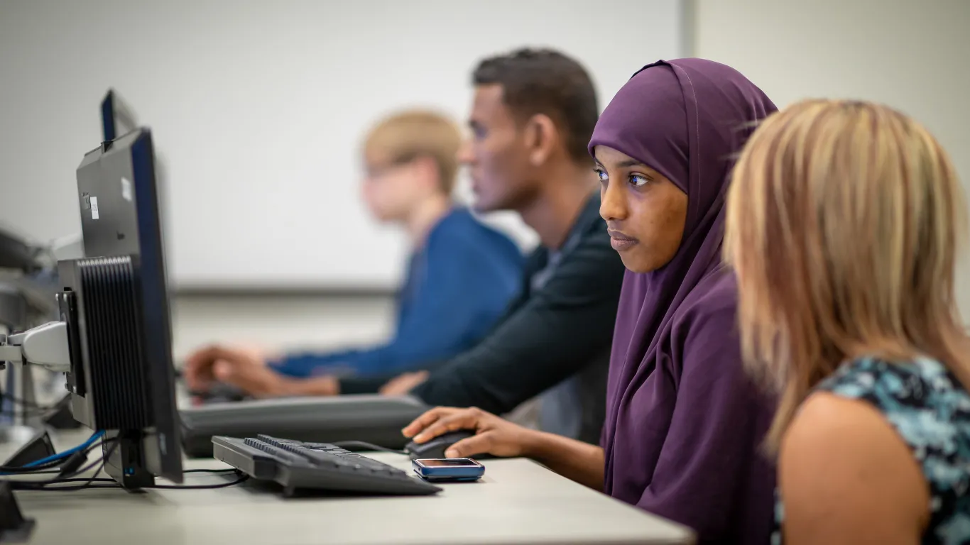 Female student at a computer with instructor