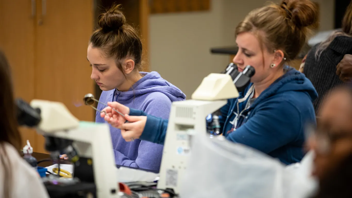 Students in biology lab working with microscopes