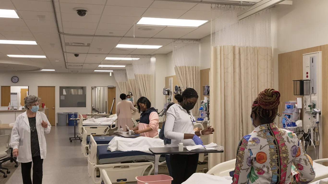 students in nursing lab with instructor walking by