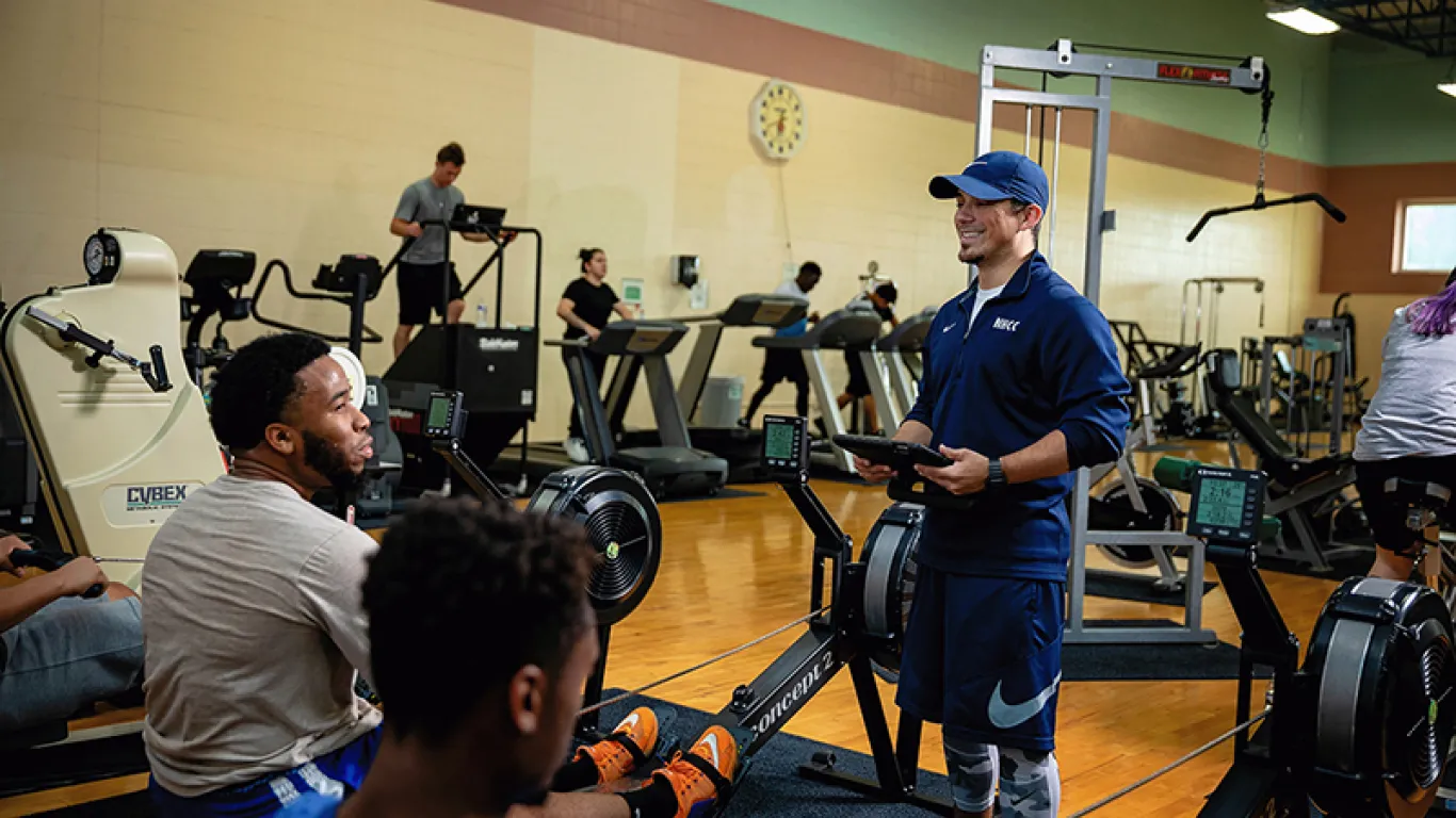 students working with instructor in a gym setting