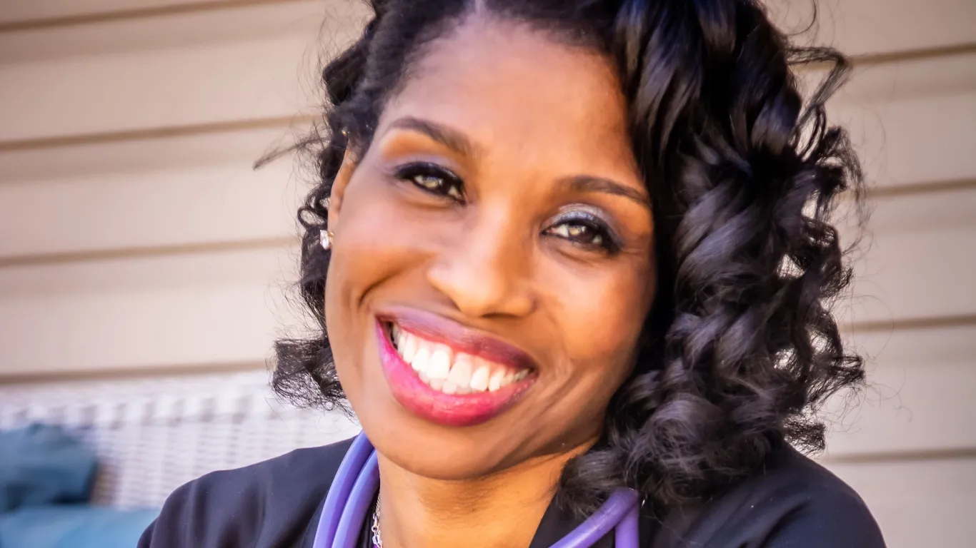 woman smiling wearing nursing uniform 