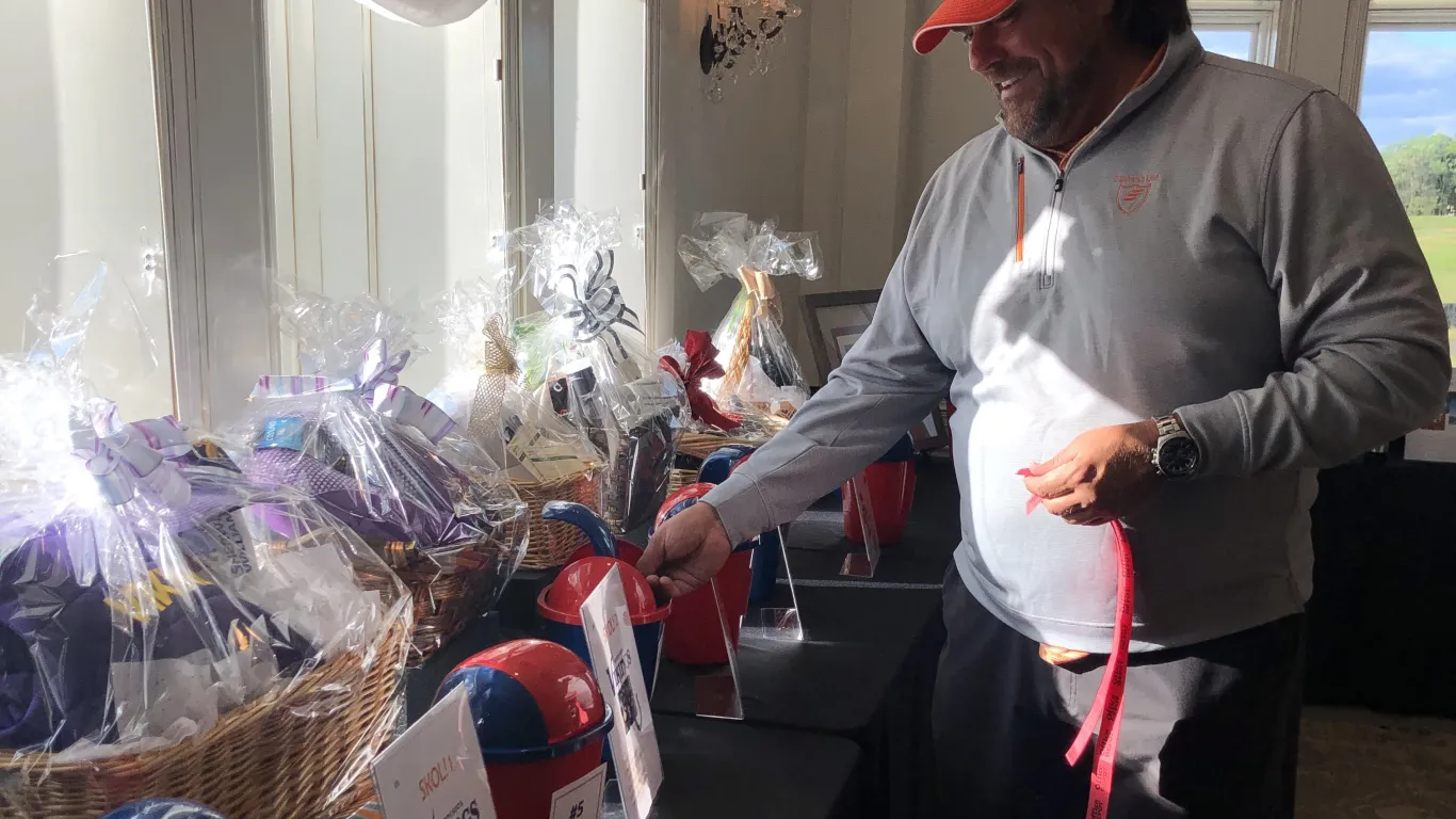 man putting a ticket into a raffle bucket for a prize 