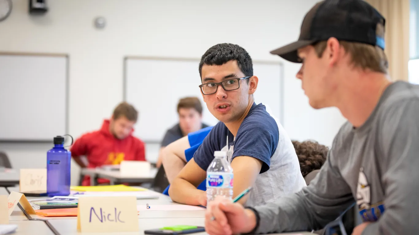 business students talking in a classroom 