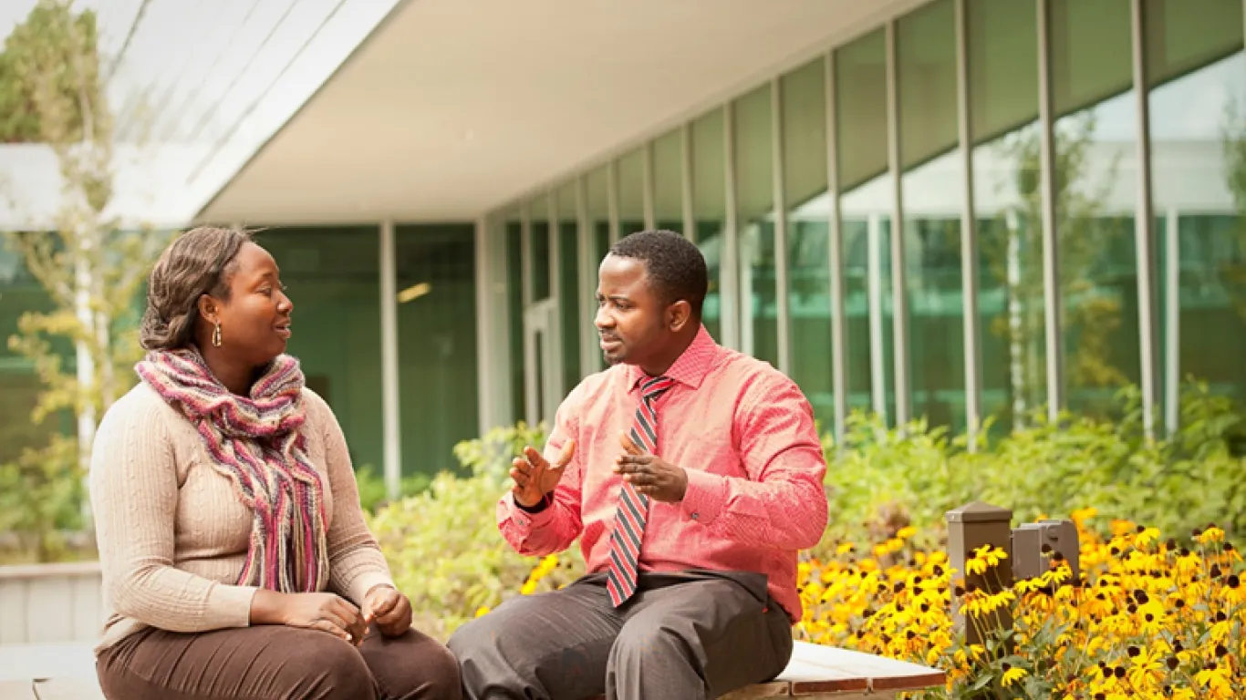 students sitting outside talking 