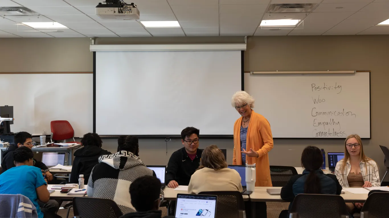 students in a classroom talking with an instructor 