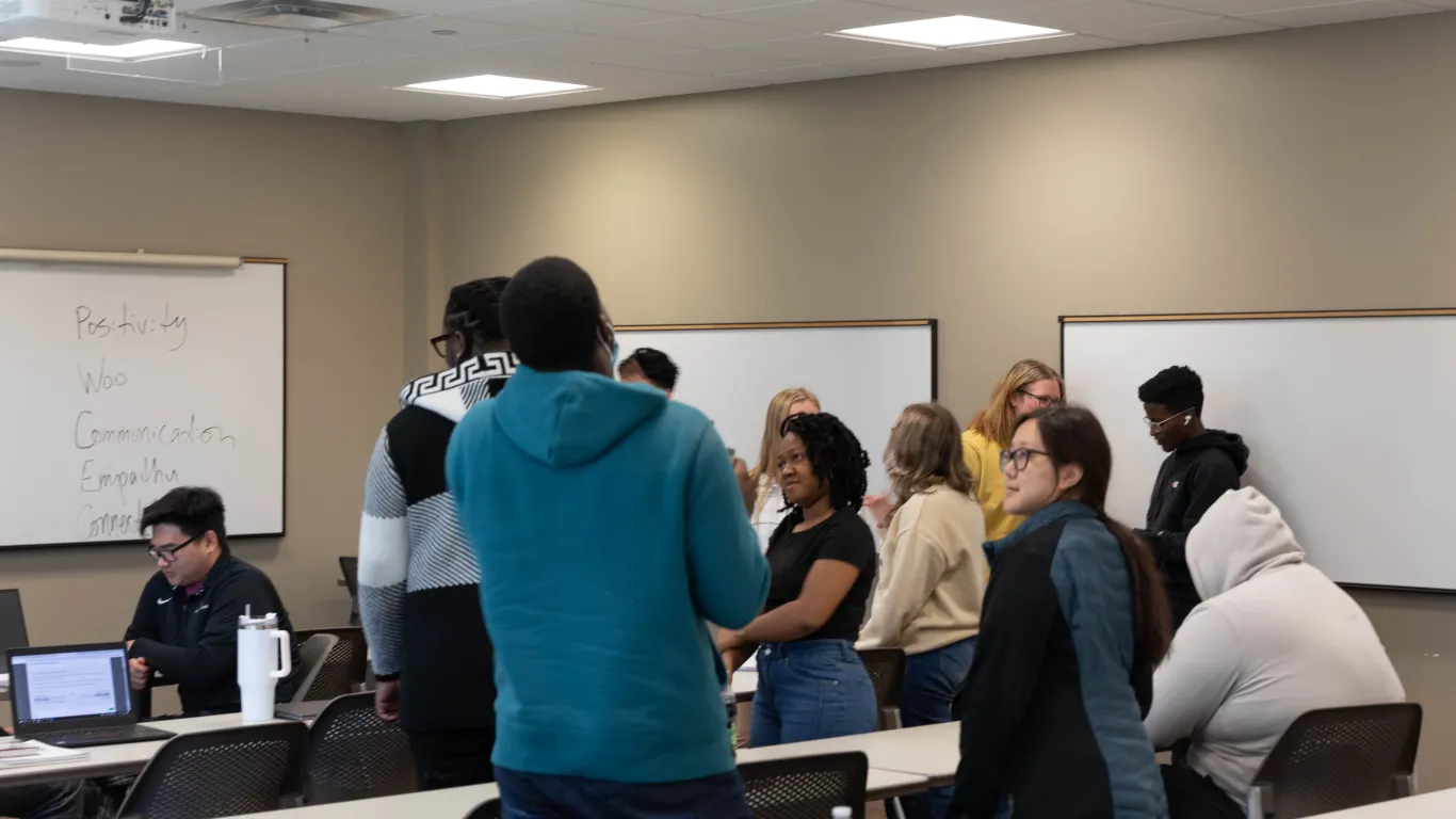 students standing and talking in a classroom 