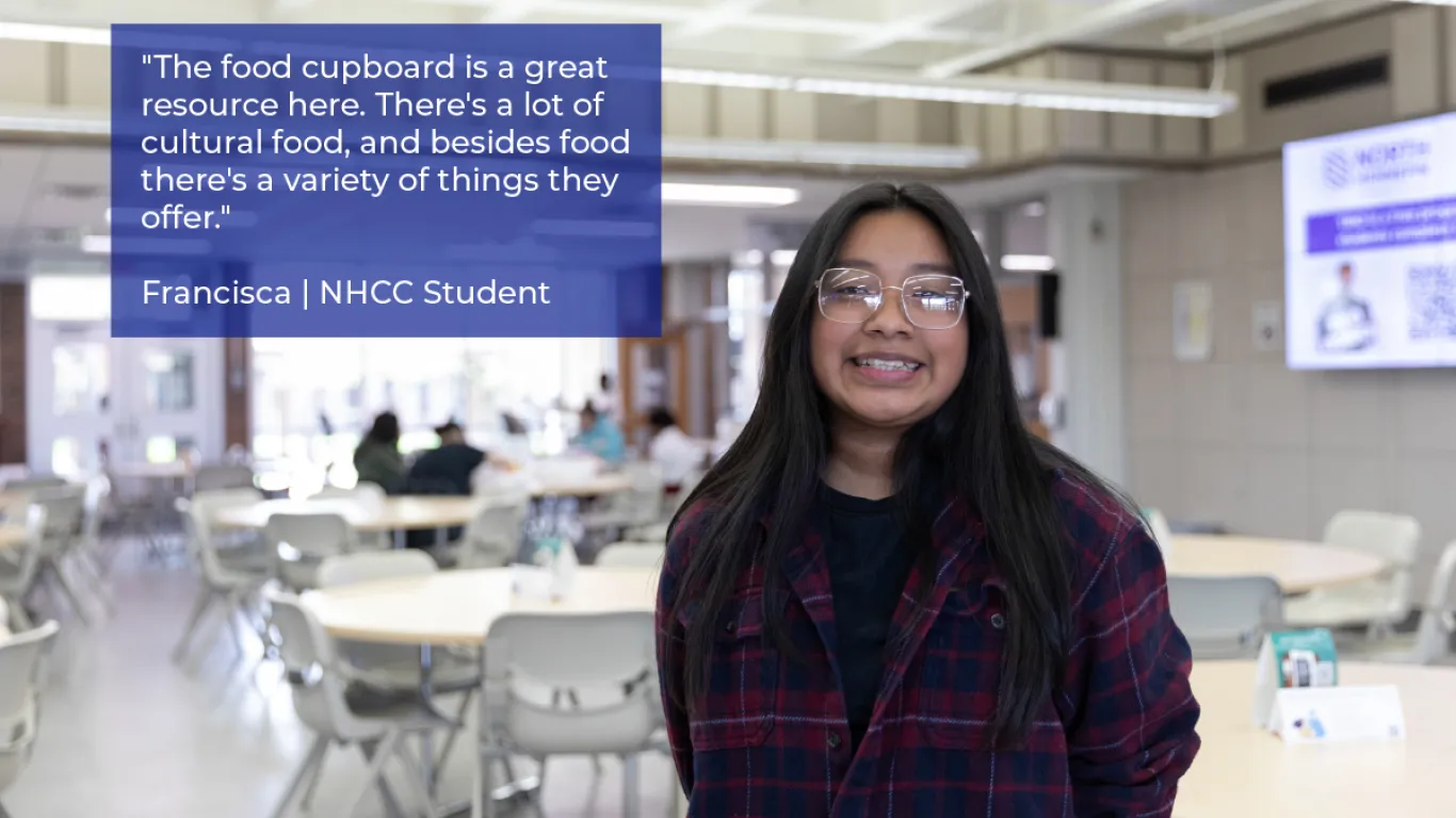 student smiling with glasses in the campus center 