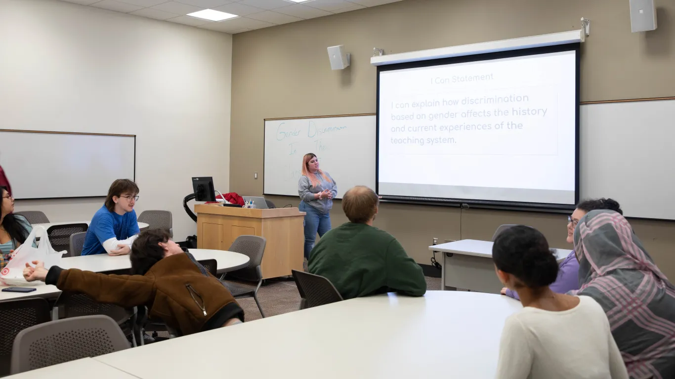 students presenting at the front of a classroom 