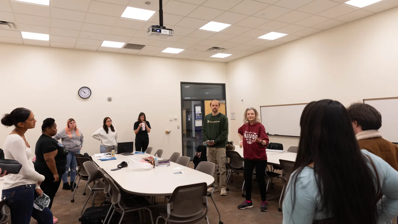 students doing an activity in a classroom standing in a circle