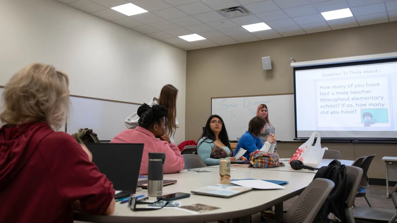 students in classroom listening to a presenter 