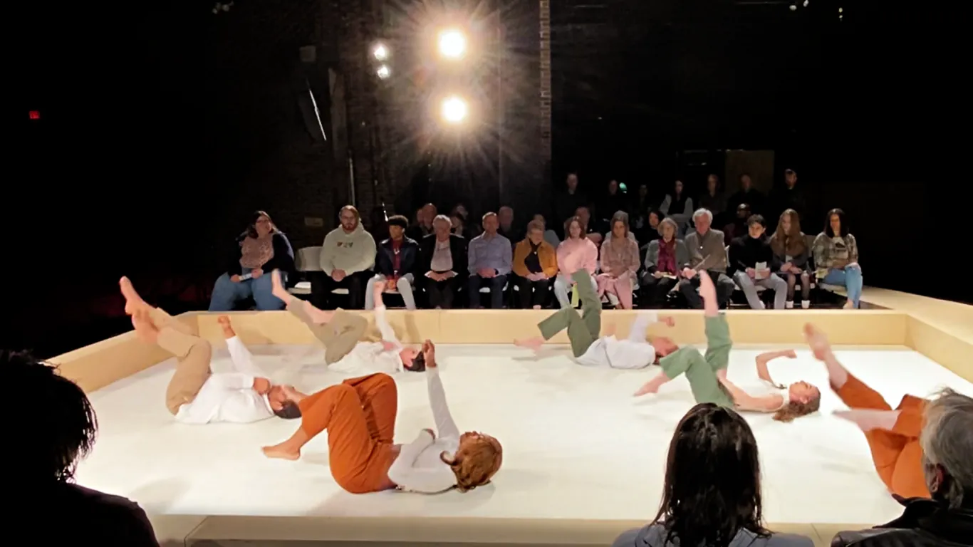 The chorus members of Antigone, lying on their backs on the stage floor.