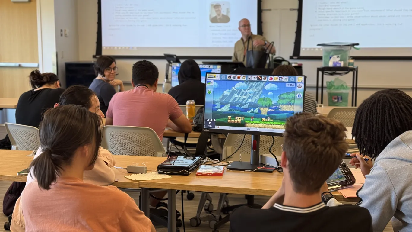 students in a classroom working on laptops 