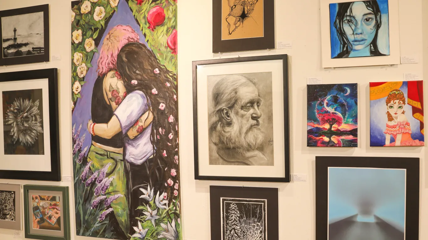 This is a group of art pieces on display in the Gallery, consisting of acrylic paintings, oil paintings, charcoal, colored pencil illustrations, linoleum block prints, ink prints and photographs.  