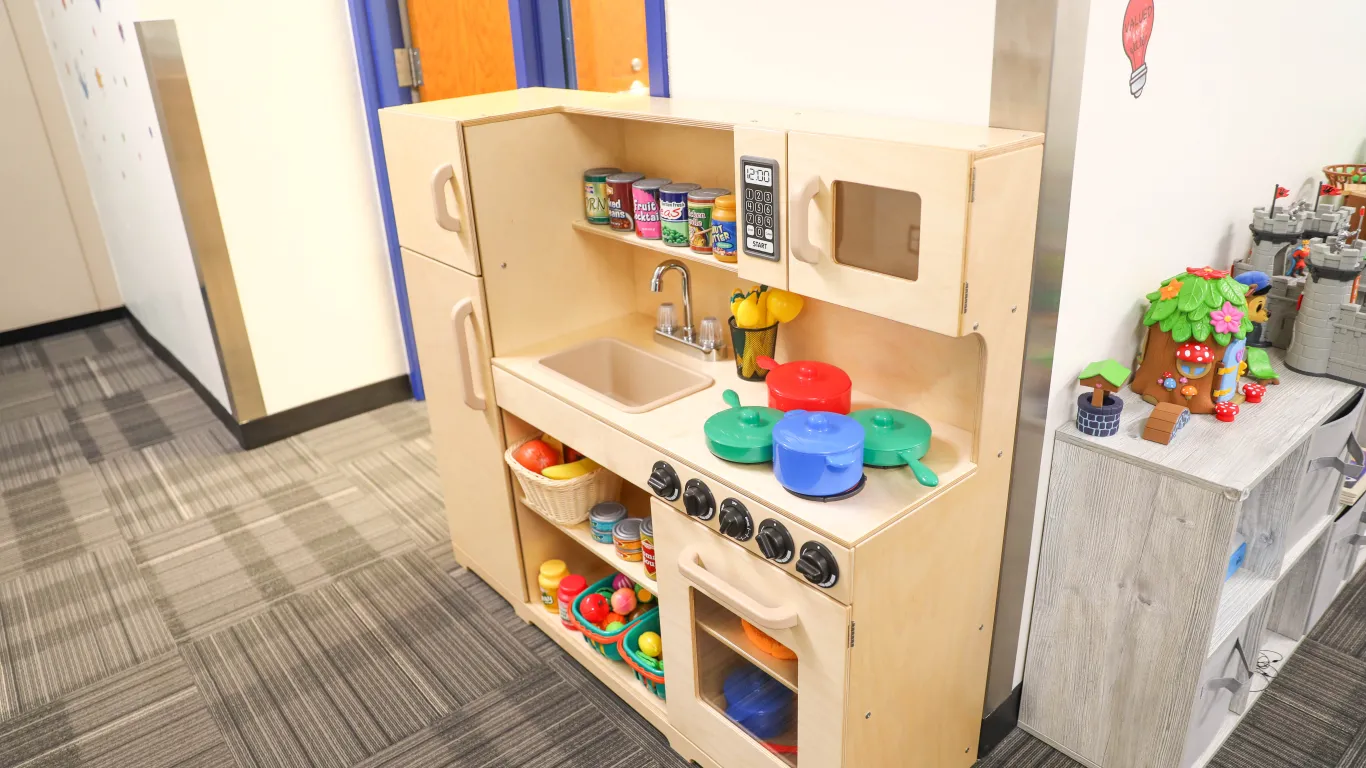 toys on shelves and a toy kitchen