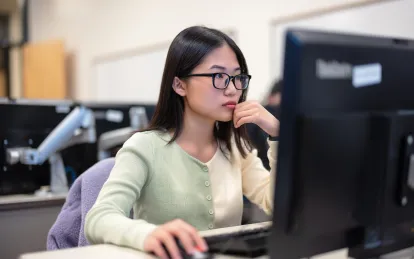 student looking at desktop computer 