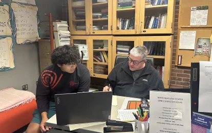 student working with a tutor at a desk