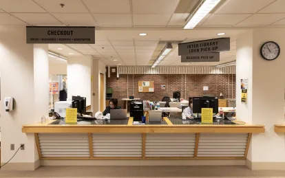 large desk with two students sitting behind it 