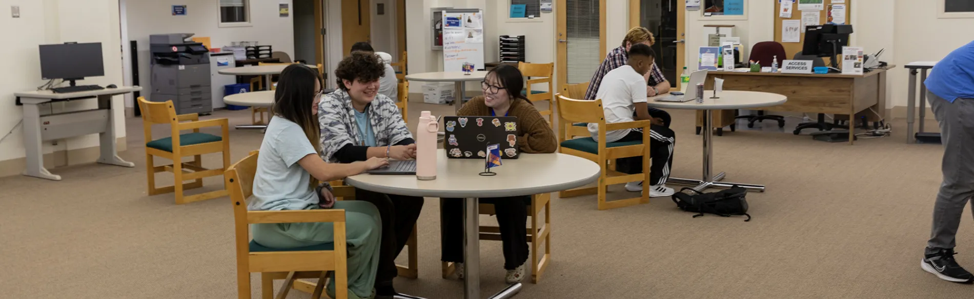 students working at a table with a tutor