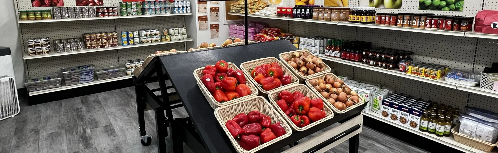 shelves with food and baskets of red peppers 