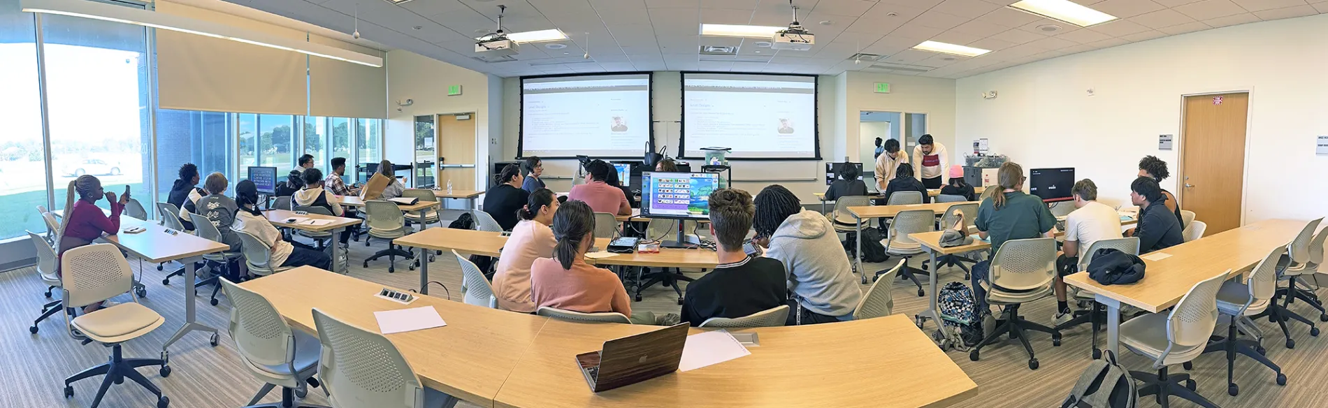 students in large classroom working on laptops