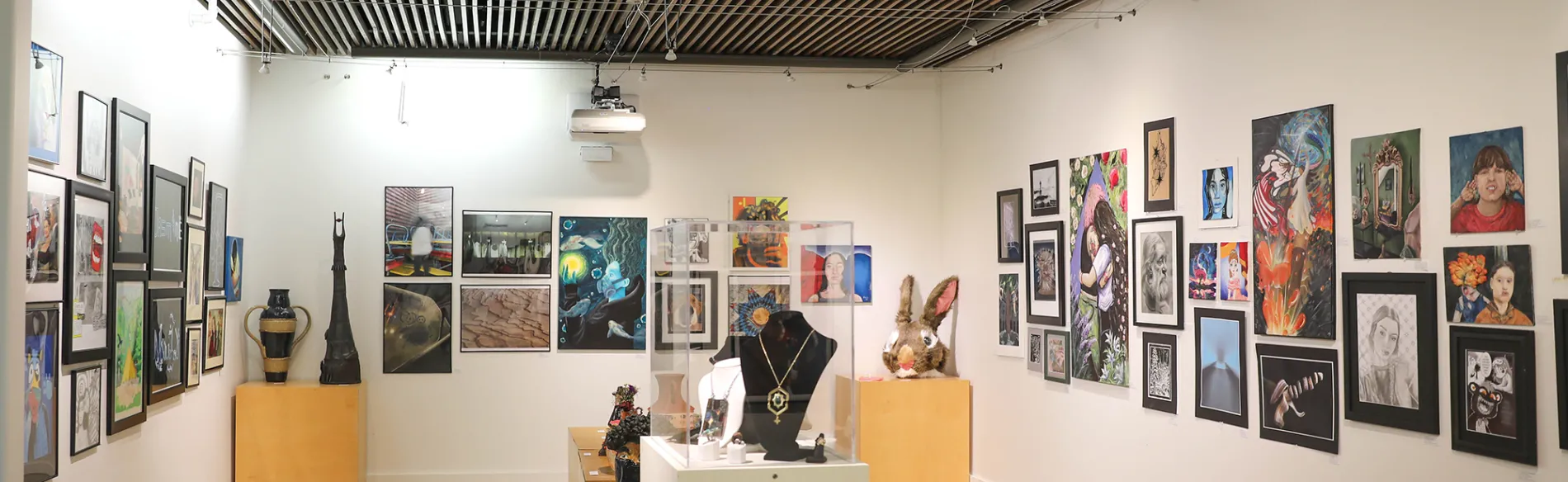 gallery with art on the walls and sculptures on tables 