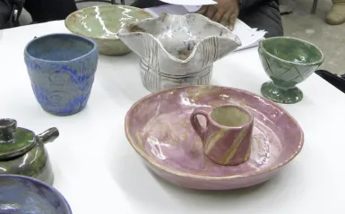 colorful ceramic bowls and mugs on a table 