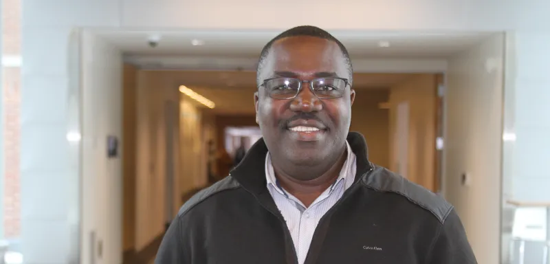 man smiling standing in a hallway