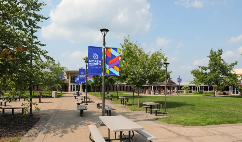 Campus courtyard with picnic tables and branded banners