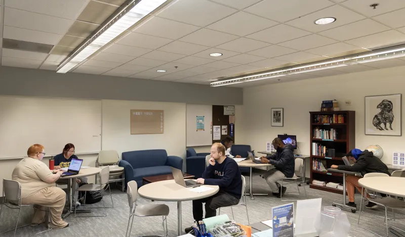 students on laptops in the writing center