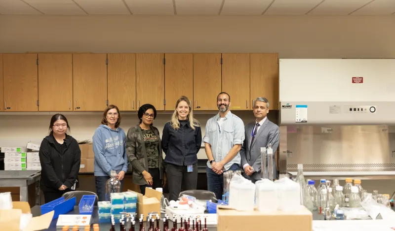 a group standing by lab equipment