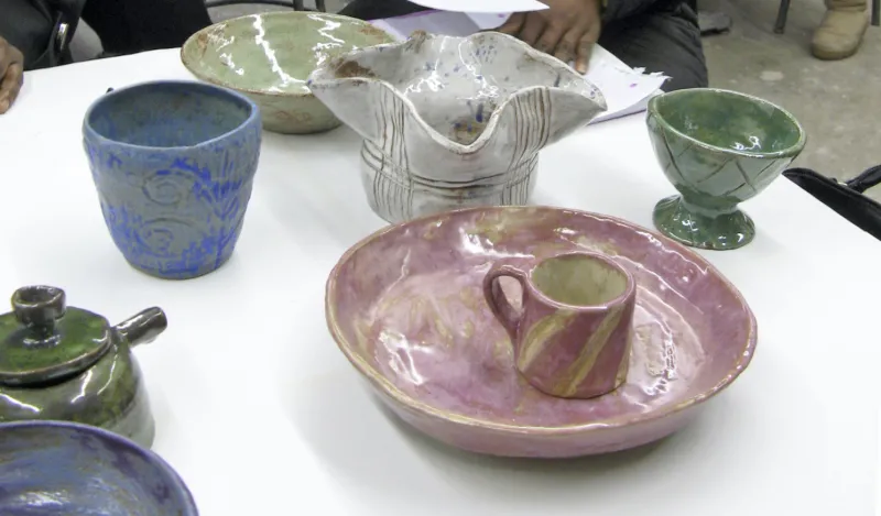 colorful ceramic bowls and mugs on a table 