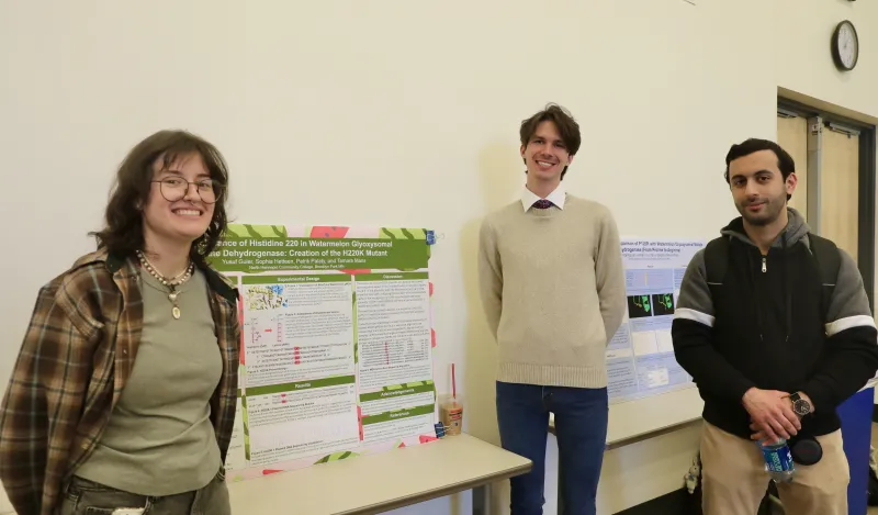 Students at NHCC+ standing next to their research poster 