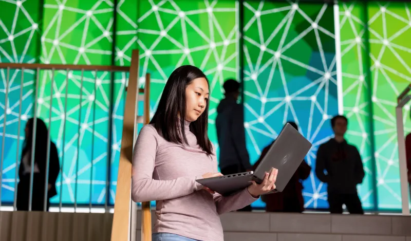 a photo of a female student with a laptop on-campus 