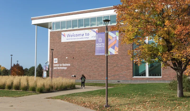 student walking into campus building in the fall