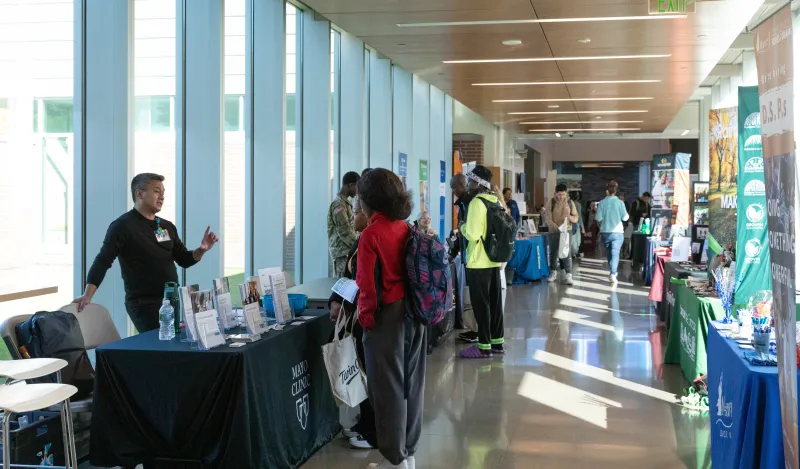 people talking by tables in a hallway