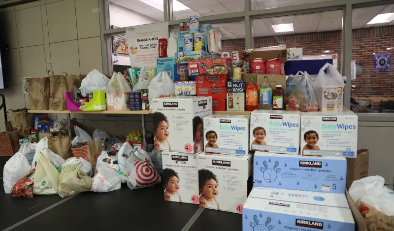 this is a photo of a pile of assorted perishable and nonperishable donations on the stage in the Campus Center during an annual Food Drive event.