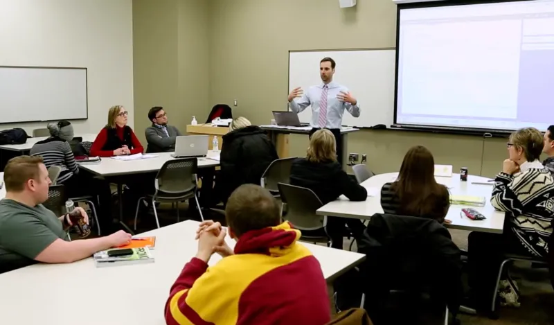 male business instructor speaking to classroom of students 