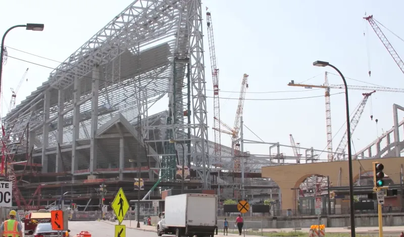 a large building construction site with cranes and workers 