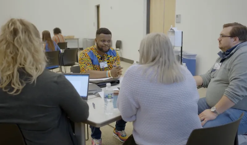 a student talking with potential employers 