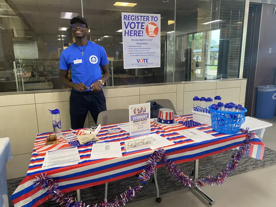 a photo of a Student Senate member at a voter registration table