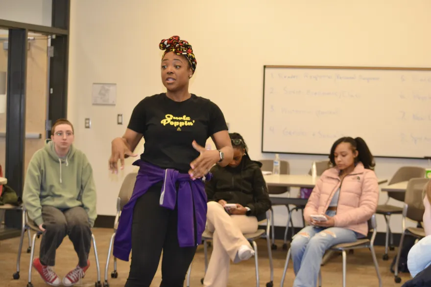 this is a photo of a female staff member from On Stage Theatre speaking to students in the classroom at NHCC. 