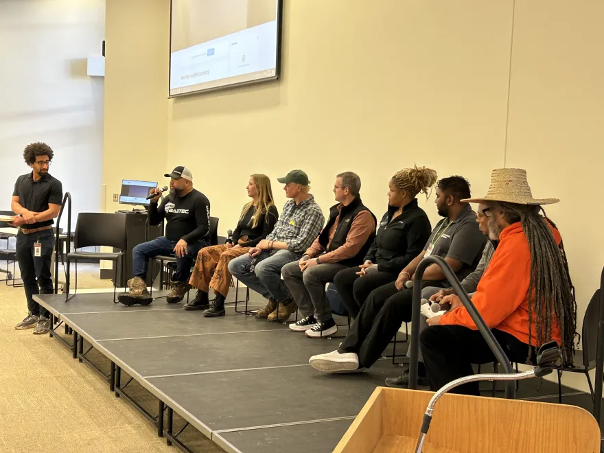 a photo of a panel of guest speakers talking with a microphone at the Green Jobs Fair event in Helling Hall on-campus.