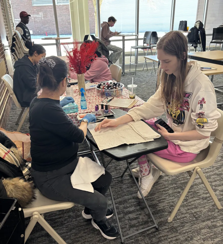 a photo of an NHCC student getting a manicure during our event in the Campus Center. 