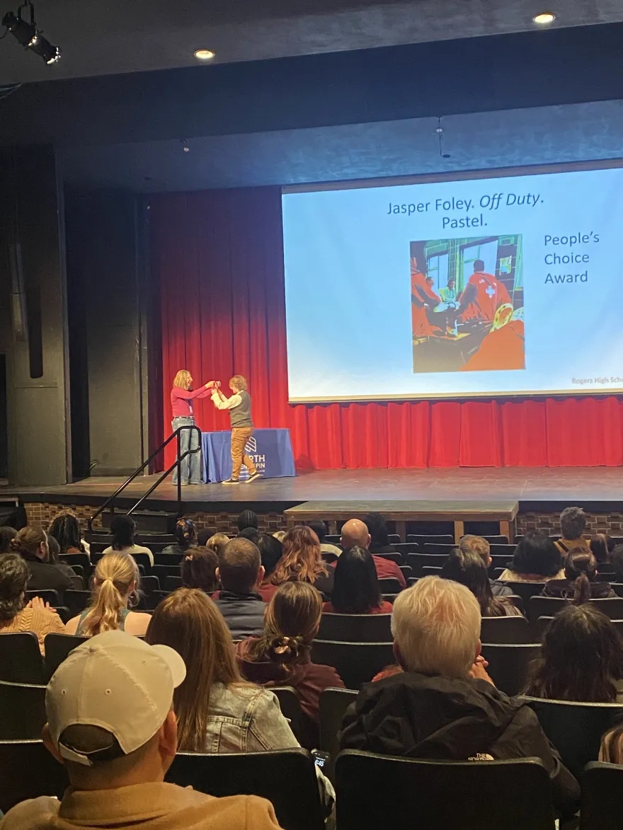 a photo of the People's Choice Award winning student artist getting their medal on stage. 