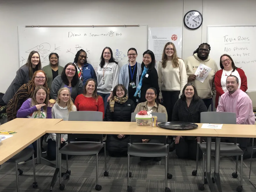 a group photo of NHCC employees at their Campus Center Cookie Swap event in December of 2024. 