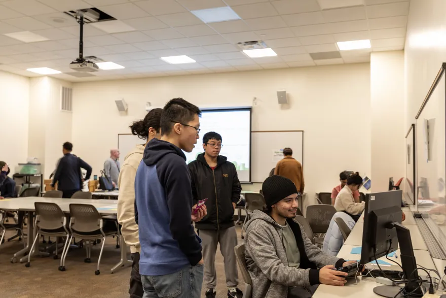 a photo of a classroom of students testing their video games on campus. 