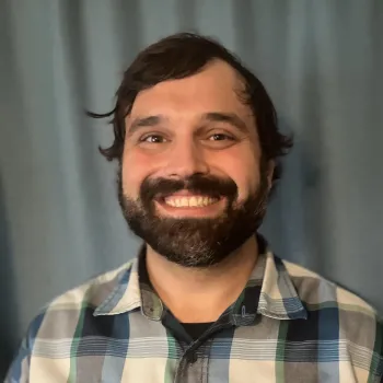 man smiling with a blue background